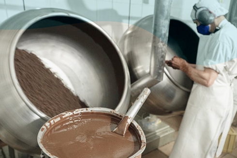 A person mixing chocolate in a large container. IDB