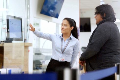 A woman pointing at a screen and talking to a man. Regional Cooperation - Inter-American Development Bank - IDB