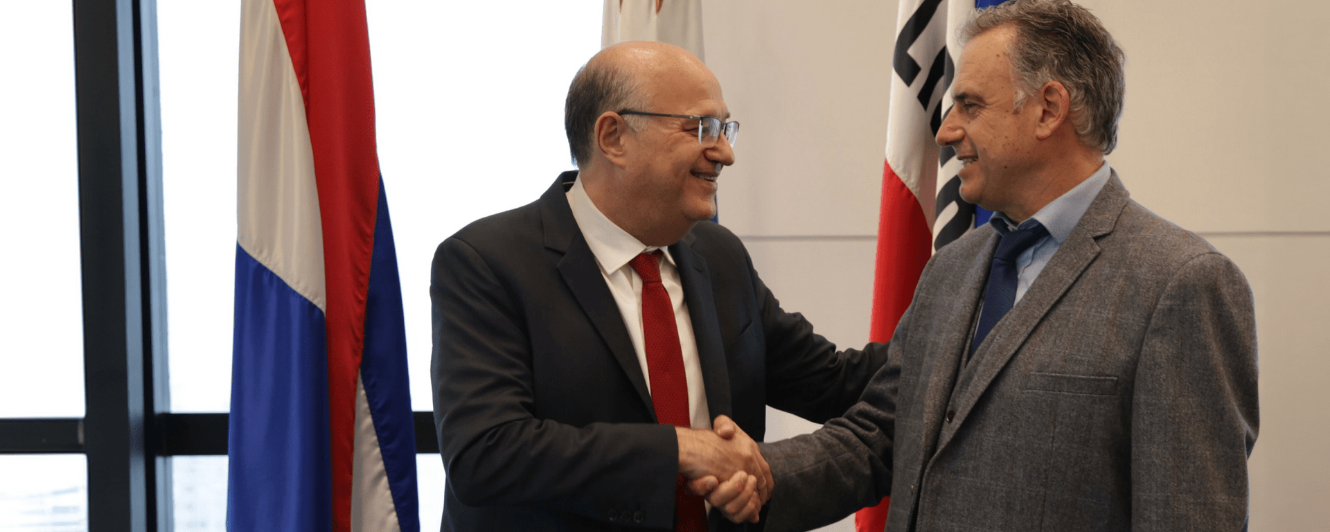Ian Goldfjan shaking hands with another person, inside a conference room - Inter American Development Bank - Private and Public Sector