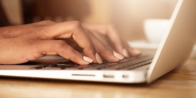A close-up of a woman's hands typing on a laptop keyboard, with focus on the keys and her fingers - Sustainable Development - Inter-American Development Bank - IDB 