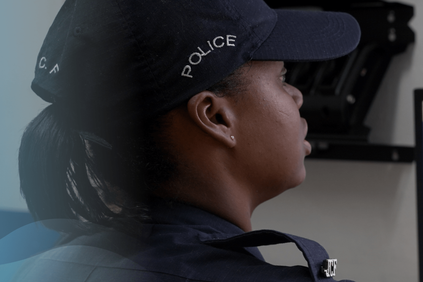 A woman police officer wearing a uniform monitors data on a computer screen in a control room, showcasing the use of AI to crack crime - Artificial Intelligence - Inter-American Development Bank