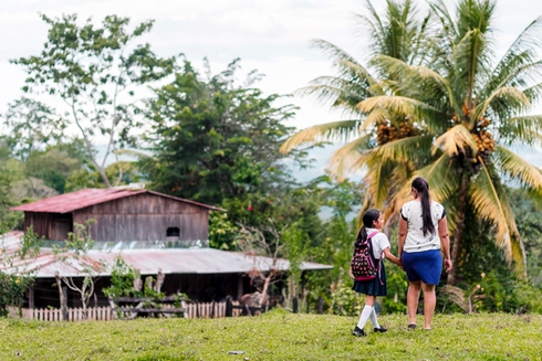 Madre llevando a su hija al colegio en el campo. Desarrollo rural y educación - Banco Interamericano de Desarrollo - BID