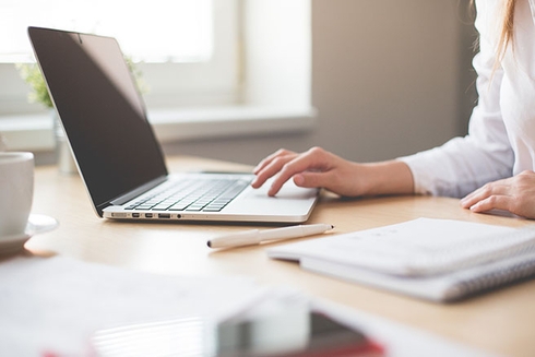 A person typing on a laptop. Consulting - Inter-American Development Bank - IDB