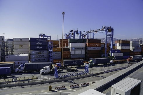 Panoramic of trucks and containers stacked in port. Logistics And Value Chains - Inter-American Development Bank - IDB