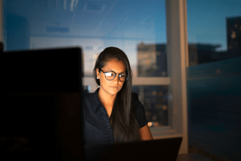 A college-aged woman looking at a computer