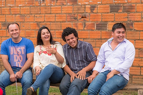 A group of people sitting on a bench and smiling