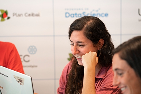 A woman staring at a laptop screen and smiling 