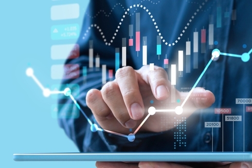 a hand touching a screen with graphs and charts