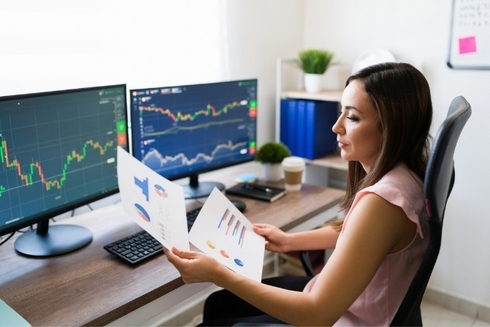 a woman sitting at a desk looking at a paper