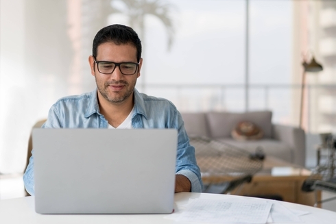 A person sitting at a table with a laptop. Sustainability - Inter-American Development Bank - IDB