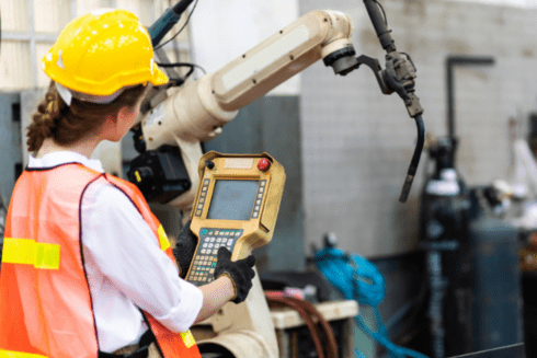 a person in a yellow hard hat using a machine employment - Inter-American Development Bank - IDB