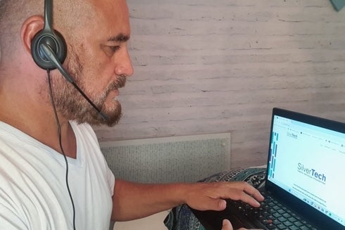 A person wearing headphones and using a laptop-IDB