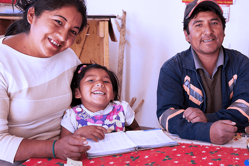 A group of people sitting at a table smiling. Social Protection - Inter-American Development Bank - IDB