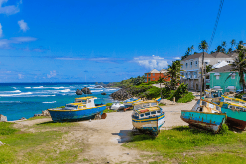 Photo of the coast of the island of Barbados showing 4 abandoned boats in the sand - Climate Change - Inter American Development Bank - IDB