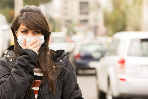 Woman covering her mouth and cars in the background - Inter American Development Bank - Research at the IDB