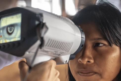 Indigenous woman receiving an eye exam with a portable machine