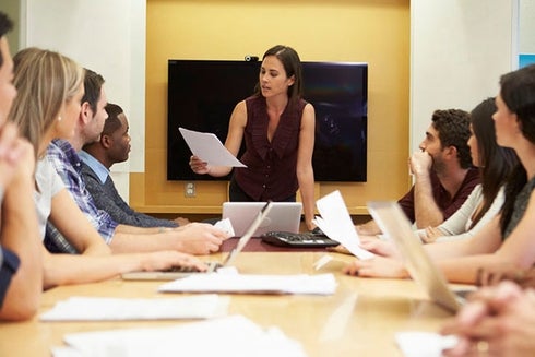 A woman giving a presentation to a group of people in a modern conference room - Future of Work- Inter-American Development Bank - IDB 