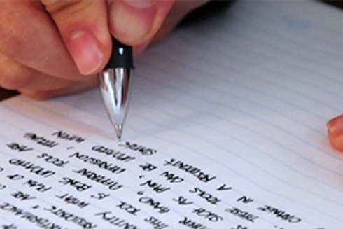 A close-up of a person writing in a notebook with a pen, with focus on their hand and the pen - Sustainable Development - Inter-American Development Bank - IDB 