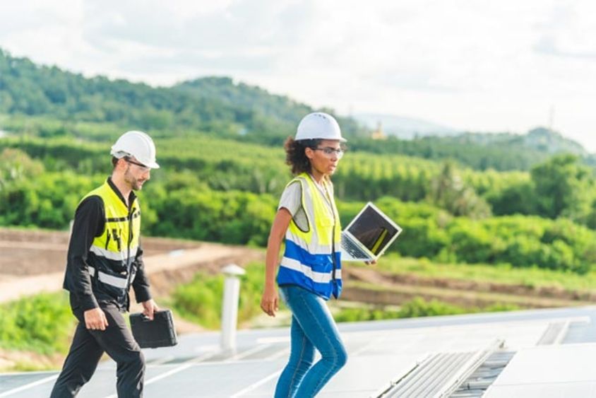 A woman and a man in safety vests walking on a roof. Climate change - Inter-American Development Bank - IDB