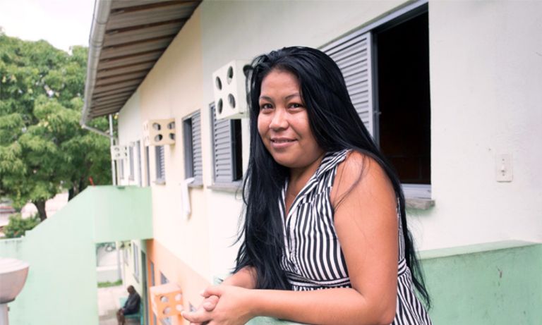 Mujer de pie en el balcón de su casa. Mejorando Vidas - Banco Interamericano de Desarrollo - BID