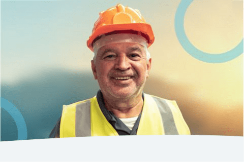 Elderly man wearing a construction helmet, smiling - Inter American Development Bank - Institutional Strategy